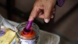 A person dips their finger in ink at a Phnom Penh, Cambodia, polling station during Cambodia's general election, July 23, 2023. A recent report by Freedom House highlighted Cambodia as one of the places that experienced attempts to control, hinder or interfere with elections. 