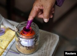 A person dips their finger in ink at a polling station on the day of Cambodia's general election, in Phnom Penh, Cambodia, July 23, 2023.