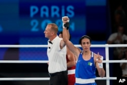 Petinju Aljazair Imane Khelif memberi isyarat setelah mengalahkan petinju Thailand Janjaem Suwannapheng dalam pertandingan semifinal tinju putri kelas 66 kg di Olimpiade Musim Panas 2024, 6 Agustus 2024, di Paris. (Foto: AP)