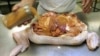 FILE - Glenn Mistich sprinkles seasoning on a turducken, a famous Louisiana specialty, at the Gourmet Butcher Block in Gretna, Louisiana, Nov. 20, 2005.