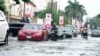 Cars drive on a flooded streets after a heavy downpour in Lagos, Nigeria, July 10, 2024. 