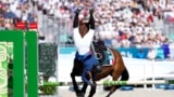 France's Marie Oteiza falls will riding Babouchka de la Bride IFCE during the final riding show of the women's individual in the modern pentathlon at the 2024 Summer Olympics, Aug. 11, 2024, in Versailles, France. 