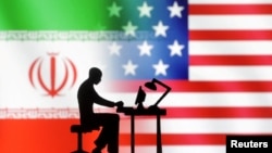 Figurines with computers are seen in front of USA and Iran flags in this illustration made on Sept. 10, 2022.