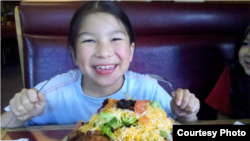 Eight-year old Nathanial LaPointe, Sicangu Lakota resident of Bothell, Wa., tucks into an enormous "Indian taco," frybread topped like a taco.