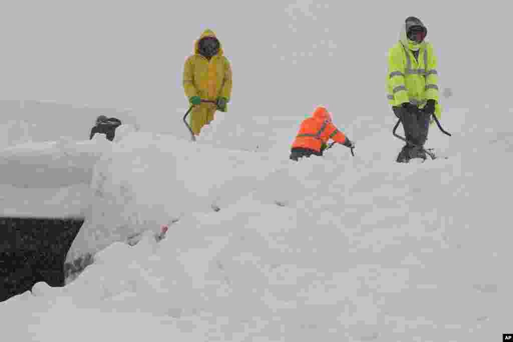 Trabajadores retiran la nieve del techo de un edificio durante la tormenta de nieve, en Olympic Valley, California.