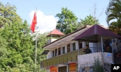 A member of the Myanmar National Democratic Alliance Army in seen in a sentry post near the flagpole that flew the MNDAA's flag at the border trading gate in Chinshwehaw town, Myanmar, Oct. 29, 2023.