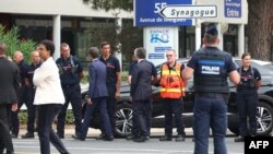 France's Prime Minister, Gabriel Attal, center left, France's Minister for the Interior and Overseas Gerald Darmanin, center right, shake hands with firefighters as they arrive at the site of a fire at a synagogue in La Grande-Motte, Aug. 24, 2024. 