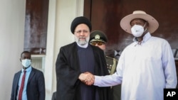 Presiden Iran Ebrahim Raisi (kiri) menjabat tangan Presiden Uganda Yoweri Museveni dalam pertemuan di Entebbe, Uganda, pada 12 Juli 2023. (Foto: AP/Hajarah Nalwadda)