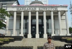 Seorang polisi Indonesia berjaga di luar Gedung Mahkamah Konstitusi di Jakarta, 20 Agustus 2014, menjelang pengumuman keputusan MK terkait perselisihan Pilpres 21 Agustus 2014. (ADEK BERRY / AFP)
