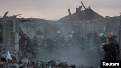 Rescuers work at the site of a Russian military strike in the village of Hroza in Kharkiv region of Ukraine, Oct. 5, 2023. 