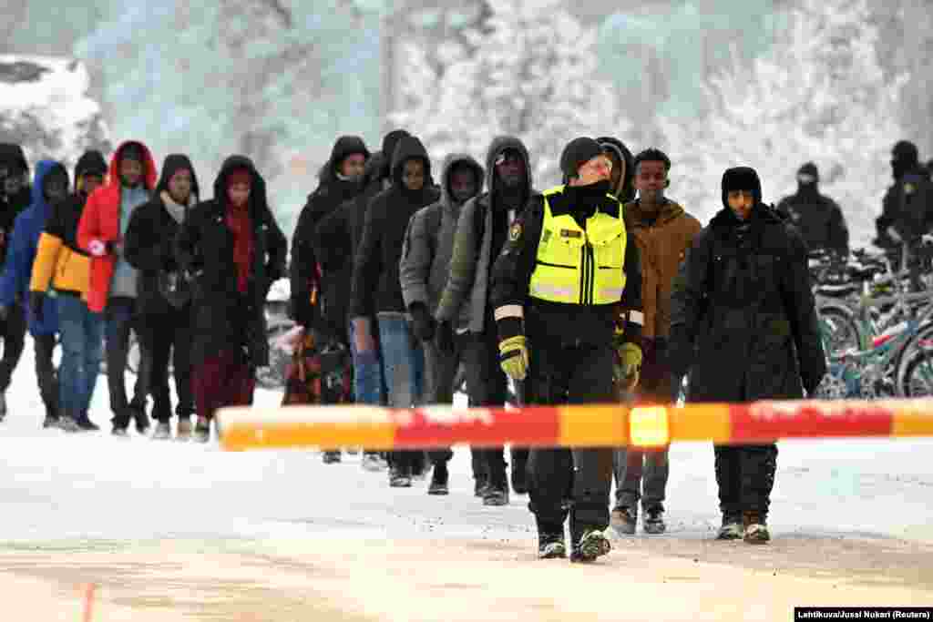 Finnish Border Guards escort the migrants at the international border crossing at Salla, northern Finland. (Lehtikuva/Jussi Nukari via Reuters)