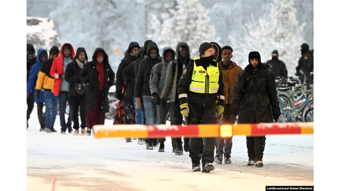 FILE - Finnish Border Guards escort the migrants at the international border crossing at Salla, northern Finland, Nov. 23, 2023. (Lehtikuva/Jussi Nukari via Reuters)