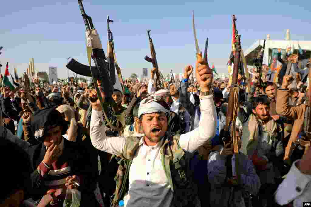 Houthi fighters brandish weapons during a protest following U.S. and British forces strikes, in the Houthi-controlled capital of Sanaa, amid the ongoing battles between Israel and the militant Hamas group in Gaza.