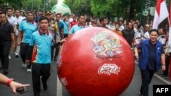 Wali Kota Solo Gibran Rakabuming Raka (kiri) bersama Ketua Umum Persatuan Sepak Bola Seluruh Indonesia Erick Thohir (kanan) dalam acara promosi trofi Piala Dunia U-17 FIFA menjelang turnamen sepak bola remaja di Solo, 5 November 2023. (DEVI RAHMAN/AFP)