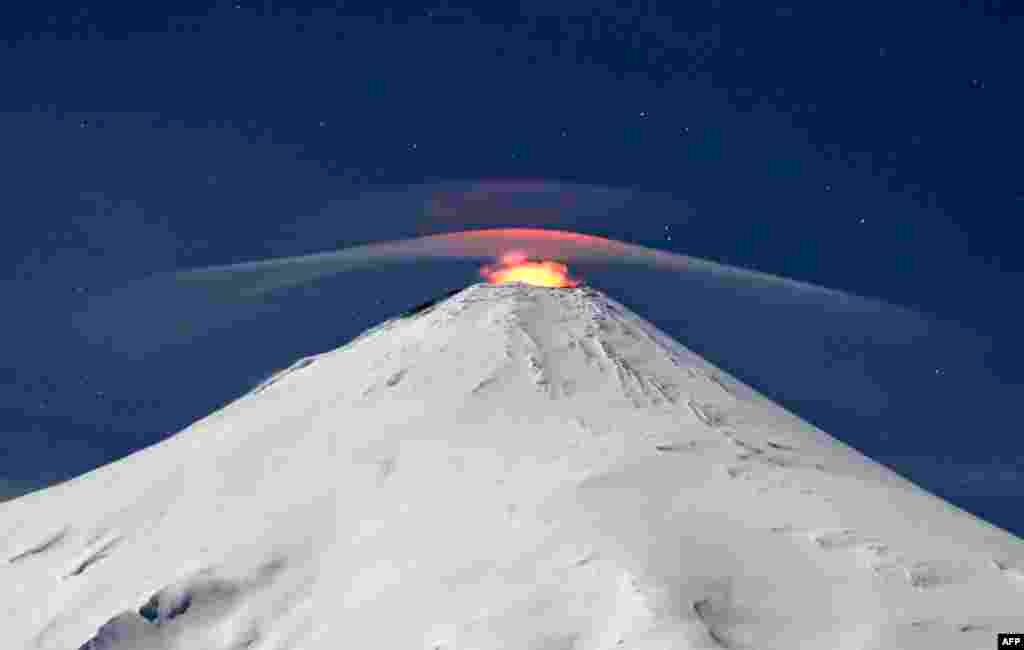 The Villarrica volcano as seen from Villarrica, some 800 kilometers south of Santiago, Chile. Villarrica is among the most active volcanoes in South America. (Photo by SEBASTIAN ESCOBAR / AFP)