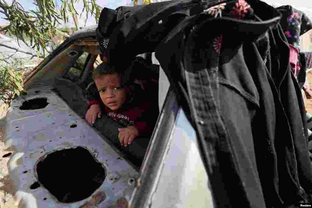 A Palestinian child looks on as displaced Palestinians, who fled their houses due to Israeli strikes, shelter in a tent camp, amid the ongoing conflict between Israel and the Palestinian Islamist group Hamas, in Rafah in the southern Gaza Strip.