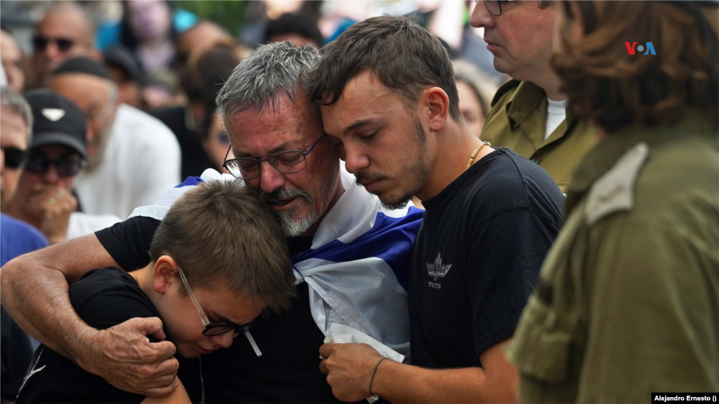 Familiares de soldados israelíes caídos durante el actual conflicto con Hamás se abrazan durante un funeral colectivo a víctimas militares, en Jerusalén, el 13 de octubre de 2023.