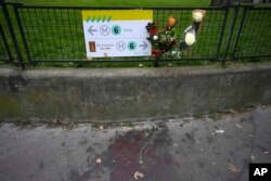 Flowers are placed on the scene where a man killing a German tourist with a knife and injuring two others in Paris, Dec. 3, 2023.