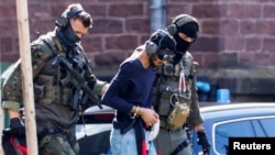 A 26-year-old Syrian man, who is the suspect in custody for a stabbing rampage in the western German city of Solingen, is escorted by police as he leaves the Federal Public Prosecutor's Office in Karlsruhe, Germany, Aug. 25, 2024.