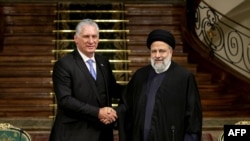 Iran's President Ebrahim Raisi, right, and his Cuban counterpart Miguel Diaz-Canel shake hands during a joint press conference at the presidential palace in Tehran, Dec. 4, 2023. (Photo by Iranian Presidency/AFP)