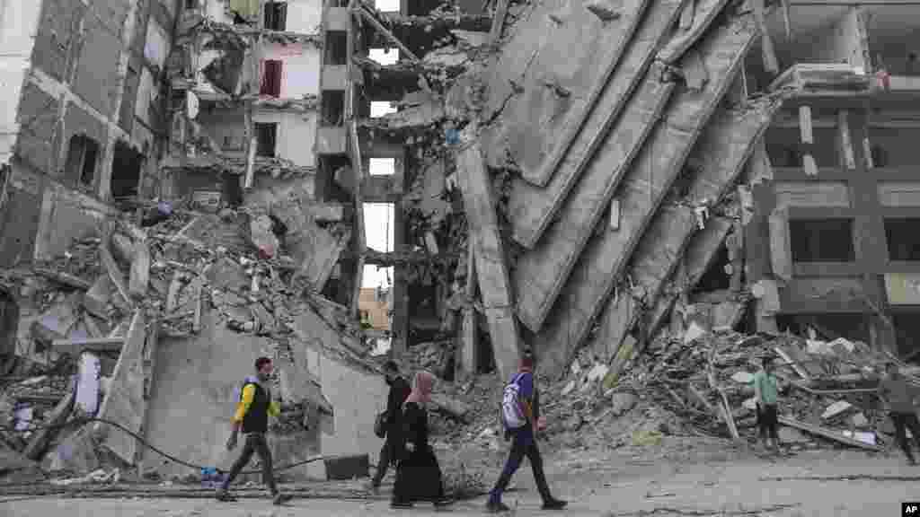 Palestinians walk through destruction in Gaza City as the temporary ceasefire between Israel and Hamas took effect. (AP Photo/Mohammed Hajjar)