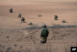 Israeli soldiers take positions near Kibbutz Kfar Azza, Oct. 10, 2023.