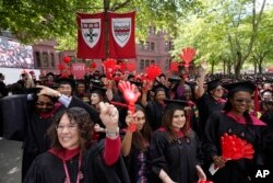 FILE - Graduating Harvard University students celebrate their graduate degrees in public health during Harvard commencement ceremonies, May 25, 2023, on the school's campus, in Cambridge, Mass.