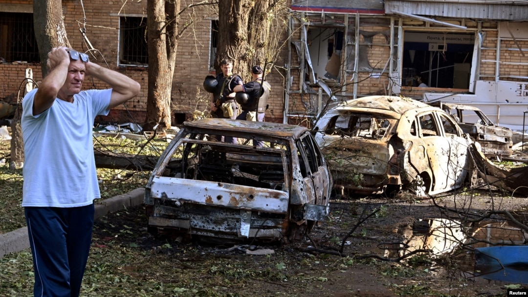 Muškarac stoji pored izgorelih automobila u dvorištu višespratne stambene zgrade, koju su prema lokalnim vlastima pogodile ostaci uništene ukrajinske rakete, u Kursku, Rusija, 11. avgusta 2024.