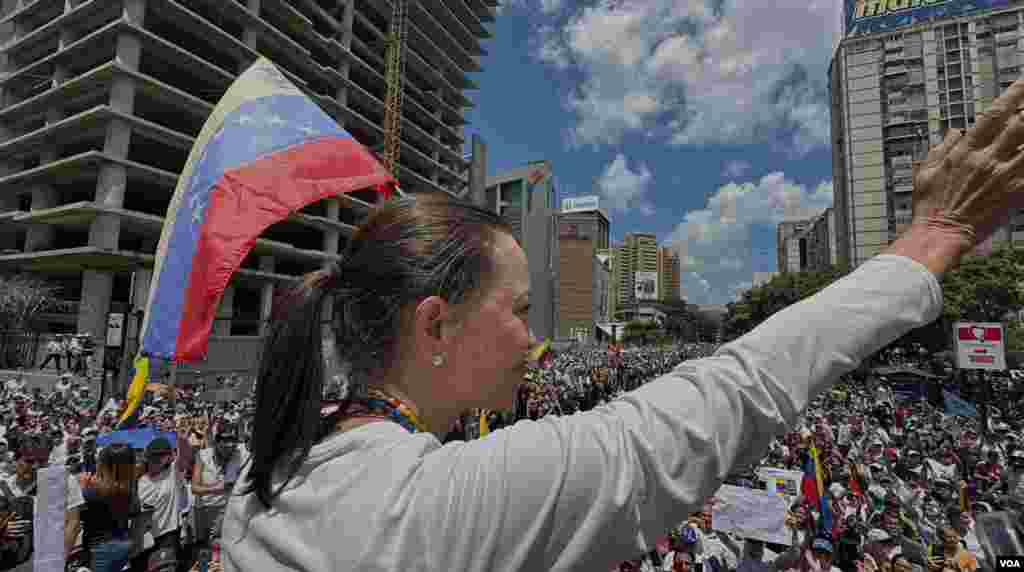 María Corina Machado, líder opositora, saluda a la multitud reunida en Caracas, Venezuela, el sábado 17 de agosto de 2024 para una protestas contra las declaraciones del Consejo Nacional Electoral dando la victoria de las presidenciales del 28 de julio al oficialista y actual presidente Nicolás Maduro. [Fotos, VOA].