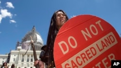 FILE - An Apache activist dancer performs in a rally to save Oak Flat, land near Superior, Arizona, sacred to Western Apache tribes, in front of the U.S. Capitol in Washington, July 22, 2015.