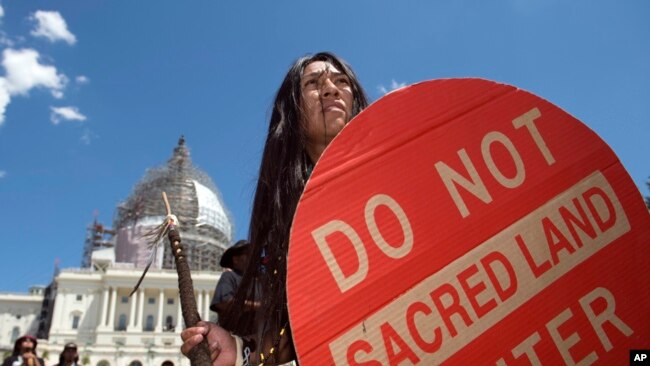 FILE - An Apache activist dancer performs in a rally to save Oak Flat, land near Superior, Ariz., sacred to Western Apache tribes, in front of the US Capitol in Washington, July 22, 2015.
