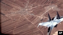 In this image from video released by the U.S. Air Force, a Russian SU-35 flies near a U.S. Air Force MQ-9 Reaper drone on July 5, 2023, over Syria.