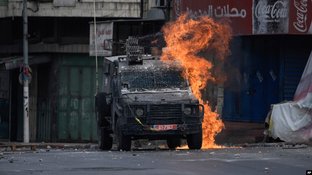 A Molotov cocktail thrown by a Palestinian protester explodes on an Israeli armored vehicle during clashes with Israeli security forces following a military raid in the West Bank city of Nablus, July 7, 2023.