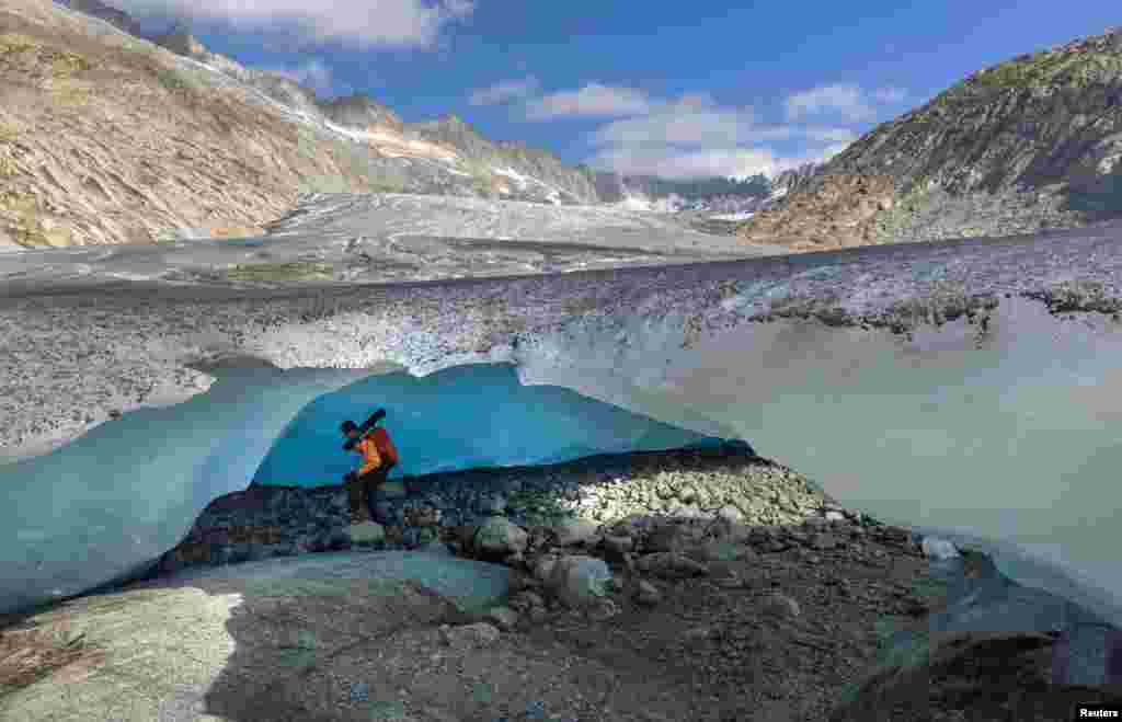 Glaciologist at ETHZ and head of the Glacier Monitoring in Switzerland (GLAMOS) Matthias Huss enters an ice cave at the tongue of the Rhone glacier amid climate change in Obergoms, Switzerland, Aug. 27, 2024. 