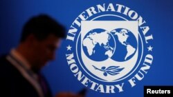 Seorang peserta berdiri di dekat logo IMF pada Pertemuan Tahunan Dana Moneter Internasional - Bank Dunia 2018 di Nusa Dua, Bali, 12 Oktober 2018. (Foto: REUTERS/Johannes P. Christo)