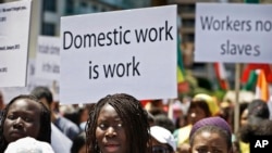 FILE - Migrant domestic workers, hold banners demanding basic labor rights as Lebanese workers, during a march at Beirut's seaside, Lebanon on Sunday, April 28, 2013. Over 200,000 workers mostly women from Asia and Africa work as maids in a country of 4 million people.