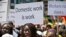 FILE - Migrant domestic workers, hold banners demanding basic labor rights as Lebanese workers, during a march at Beirut's seaside, Lebanon on Sunday, April 28, 2013. Over 200,000 workers mostly women from Asia and Africa work as maids in a country of 4 million people.