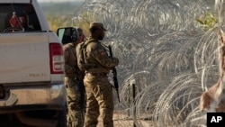 Los guardias vigilan junto una alambrada de concertina a lo largo de las orillas del Río Grande, el viernes 22 de septiembre de 2023, en Eagle Pass, Texas, EEUU.