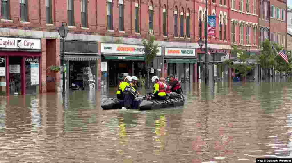 Emergency services workers use a boat to traverse Montpelier, Vermont, in this still image taken from video obtained on social media.