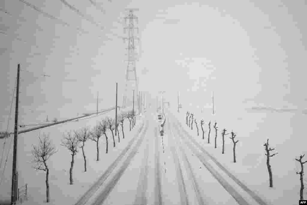A road is seen during snowfall from a train window along the Tokaido Shinkansen, part of the nationwide high-speed railway network, in Ogaki city of Gifu Prefecture, Japan.
