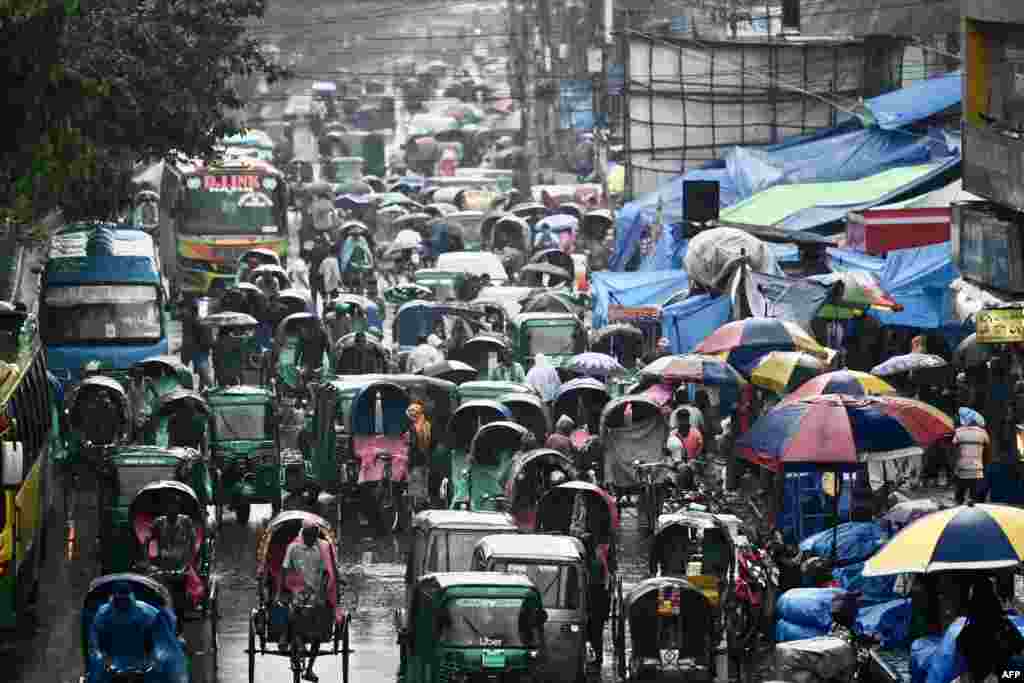 Vehicles make their way along a busy road during a rainfall in Dhaka, Bangladesh.