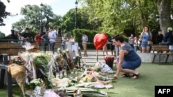 FILE - A woman honors victims of a June 8, 2023, stabbing attack in a park in Annecy, French Alps, on June 9, 2023. Authorities in southern China said Monday that an attacker killed six people and wounded another at a kindergarten in China. Police said a suspect was in custody.