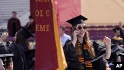 FILE - A graduating Boston College student speaks on a phone during commencement ceremonies on May 22, 2023, in Boston. 