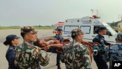尼泊尔西部11月4日发生强烈地震。 救援的军人抬着受伤人员离开山村。