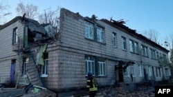 This handout photograph taken and released by Ukrainian Emergency Service on Nov. 25, 2023, shows a rescuer working at the site of a drone attack in Kyiv. (Photo by Handout / Ukrainian Emergency Service / AFP)