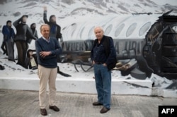 Daniel Fernandez (kiri), salah satu dari enam belas orang Uruguay yang selamat dari kecelakaan Penerbangan 571, dan jurnalis, penulis, dan penulis skenario Uruguay Pablo Vierci di depan mural buatan Graff Express di Montevideo, 15 November 2023. (Eitan ABRAMOVICH / AFP)