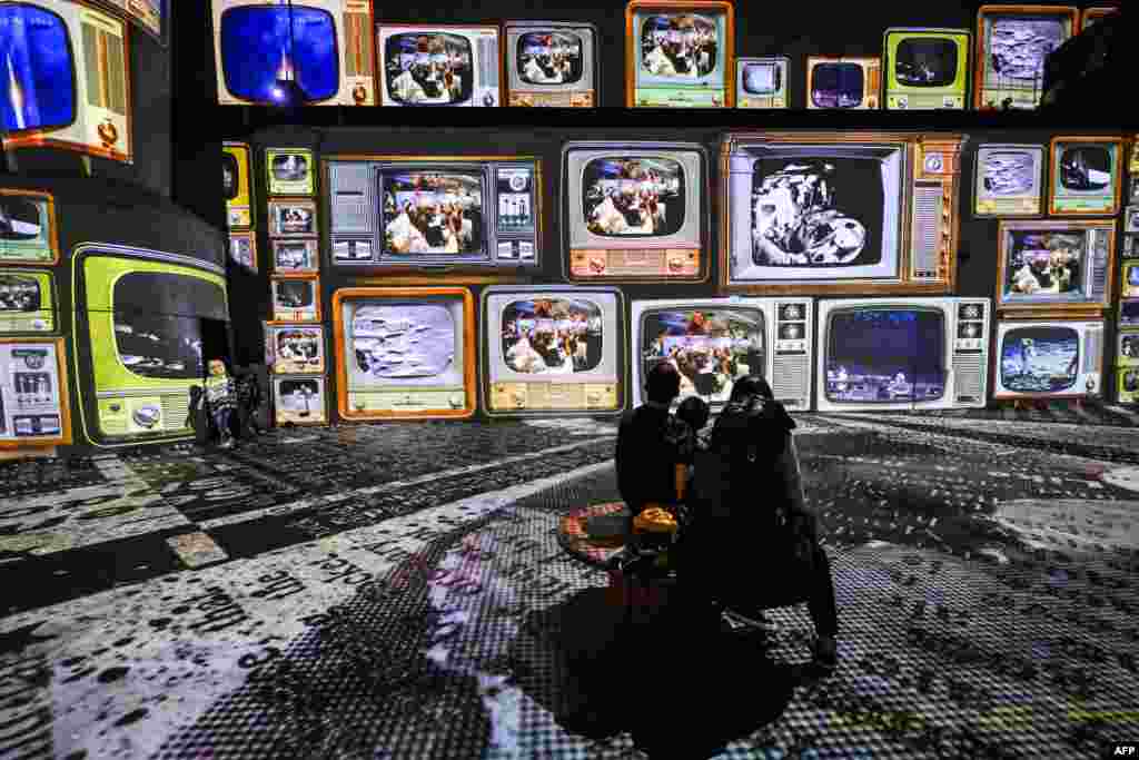 Visitors look at the new digital exhibition &#39;Destination Cosmos - An Infinite Journey&#39; at the former gas plant Phoenix West in Dortmund, western Germany.