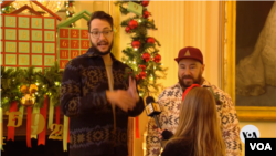 White House volunteers Andrew Boza (left) and Dennis Setteducati discuss their experience helping to decorate the executive mansion for the holidays, Nov. 27, 2023, in Washington.