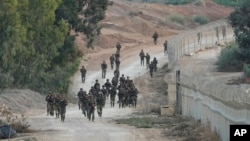 Israeli soldiers patrol near Kibbutz Be'eri, Israel, Oct. 11, 2023. The kibbutz was overrun by Hamas militants from nearby Gaza Strip Saturday. 