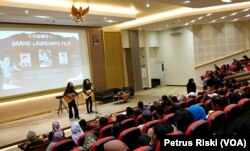 Dua musisi membawakan lagu tentang hilangnya 13 mahasiswa saat Reformasi 1998, di awal pemutaran film Yang (Tak Pernah) Hilang. (VOA/Petrus Riski)